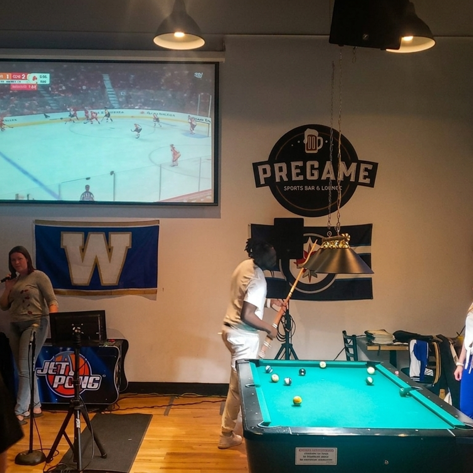 Sports bar with pool table, patrons, hockey game screens, and Pregame Sports Bar & Lounge décor.